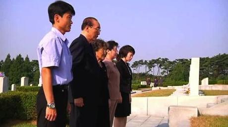 Supreme People's Assembly Presidium Vice President Yang Hyong Sop and members of his family visit a grave at the Patriotic Martyrs Cemetery in Pyongyang on 19 September 2013.  Yang's wife (also seen in the image) is a member of the extended Kim Family (Photo: KCNA screengrab).
