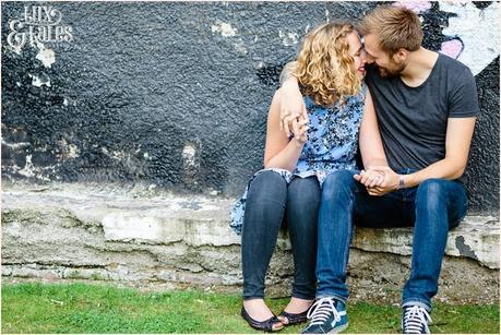 Engagement shoot pose of couple in Sheffiled in front of mural 