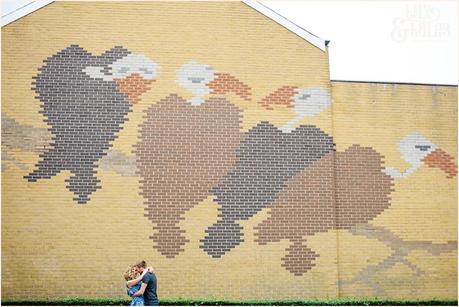 Couple pose in front of a mural of vultures in Sheffiled City Centre 