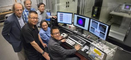Brookhaven Lab scientists Radoslav Adzic, Vyacheslav Volkov, Lijun Wu (back), Wei An, Jia Wang, and Dong Su (front) gathered in the control room for a scanning transmission electron microscope (STEM) in the Center for Functional Nanomaterials. (Credit: Brookhaven National Laboratory)