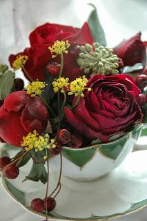 This screams Christmas!  Falstaff and Black Baccara roses with fennel and ivy flowers in a victorian fluted teacup. By Tuckshop Flowers.