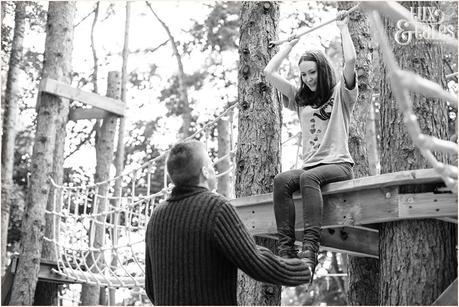 Engaged couple playing on ropes at Stockeld Park 