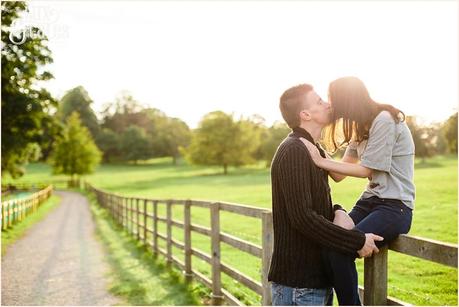 Girl sits on fence kissing fiance at Stockeld Park Yorkshire