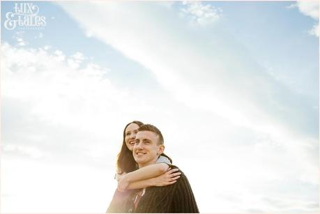 engaged couple hugging on a sunny day taken from a low angle