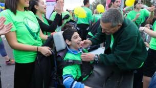 Doron Almog puts a medal on a child from ALEH Jerusalem at the Jerusalem Marathon (photo credit: courtesy Aleh)