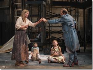 Beatriz (ensemble member Joan Allen, left) is paid to help a soldier (ensemble member Tim Hopper, right) as The Boy (Daniel Pass) and The Girl (Emma Gordon) look on in Steppenwolf Theatre Company’s American-premiere production of The Wheel by Zinnie Harris, directed by ensemble member Tina Landau.  (photo credit: Michael Brosilow)