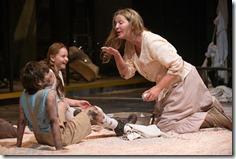 (right to left) Beatriz (ensemble member Joan Allen) shares the soap she just purchased with The Girl (Emma Gordon) and The Boy (Daniel Pass) in Steppenwolf Theatre Company’s American-premiere production of The Wheel by Zinnie Harris, directed by ensemble member Tina Landau. (photo credit: Michael Brosilow)