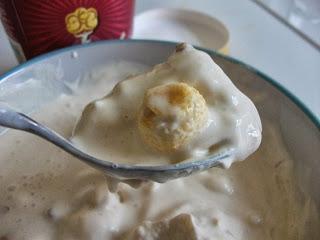 A tub of popcorn flavoured ice cream with toffee sauce, popcorn and crunchy toffee pieces