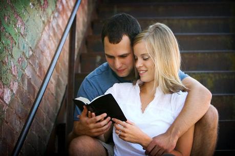 young-couple-reading-bible-on-stairs