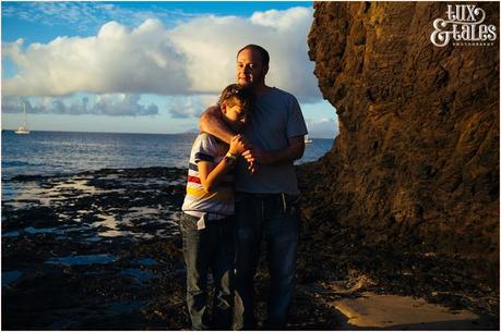 Man hugs son at papagayo beach in Lanzarote