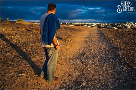 Cat follows man through volcanic dunes in Lanzarote