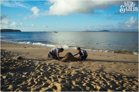 man and son build a sand castle at paapgayo beach in Lanzarote with ocean in the background