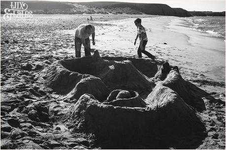 man and son build a sand castle at paapgayo beach in Lanzarote black and white 