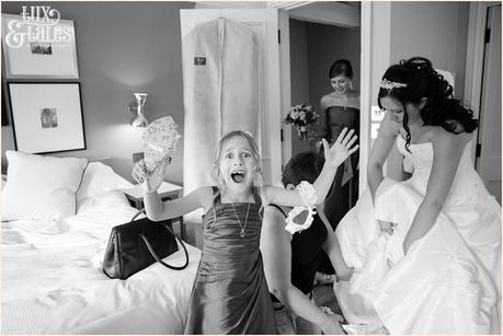 brides daughter makes a silly face for the camera as the bride gets ready for wedding in background 