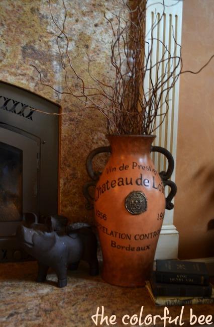 an orange French vase on a fireplace hearth