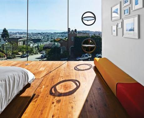 Modern master bedroom with porthole windows and wooden flooring