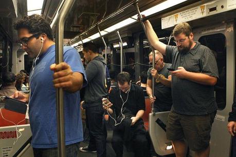 Brandon Long (right) is among the many commuters using smartphones on the way to work on a Muni train stopping at San Francisco's Powell Street Station on Friday. Photo: Liz Hafalia, The Chronicle