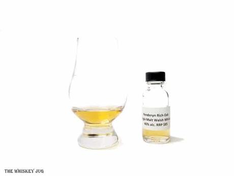 White background tasting shot with the Penderyn Rich Oak Single Malt sample bottle and a glass of whiskey next to it.