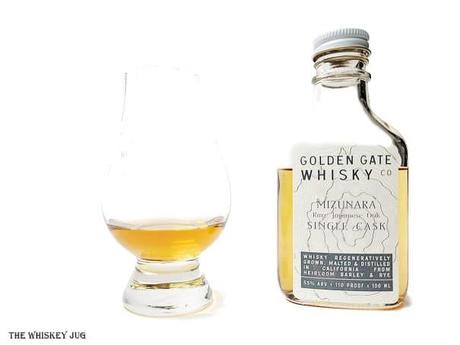White background tasting shot with the Golden Gate Whisky Mizunara Single Cask bottle and a glass of whiskey next to it.