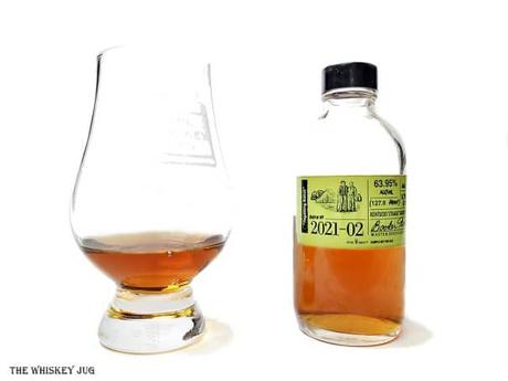 White background tasting shot with the Booker's Tagalong Batch 2021-02 bottle and a glass of whiskey next to it.