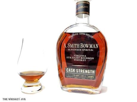 White background tasting shot with the A. Smith Bowman Cask Strength 10 Years bottle and a glass of whiskey next to it.