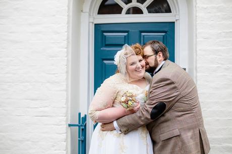 Couple pose for fun wedding photographs in front of blue door outside Grays Court