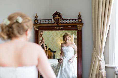 Bride looks at herself in mirror at Grays Court
