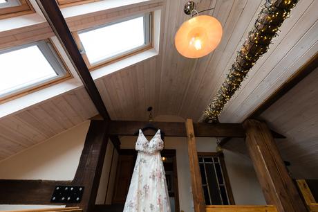 Flowered wedding dress hainging from rafters