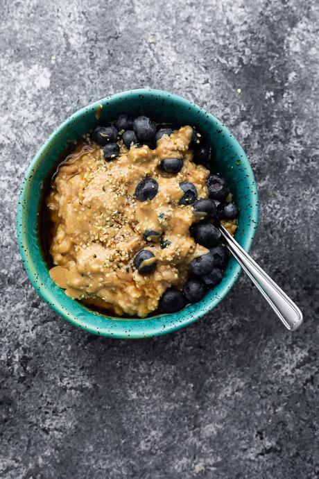 oatmeal in blue bowl with peanut butter and blueberries