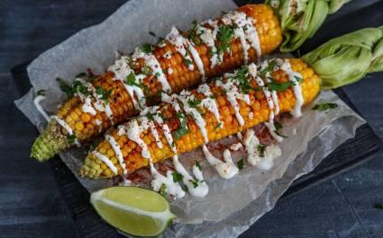 Elote or Mexican grilled corn on the cob served with cotija cheese and chili powder