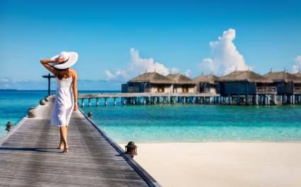 Asian couple enjoying romantic luxury lunch setting at tropical beach in Maldives