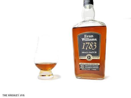 White background tasting shot with the Evan Williams 1783 Small Batch bottle and a glass of whiskey next to it.