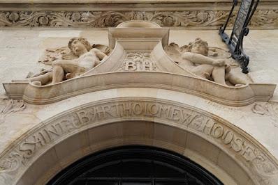 Photograph showing the carved doorway arch from a different angle. To either side, carved putti are visible.