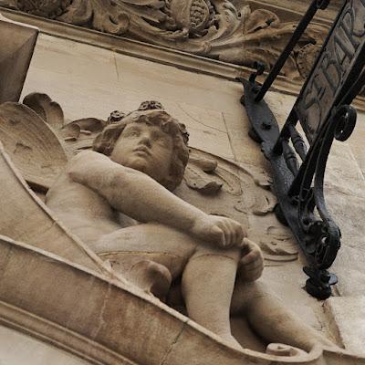 Photograph of one of the carved putti, with butterfly-like wings and flowers in its hair