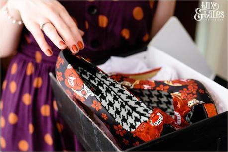 Wedding photography of a bride showing off red and black tattoo themed shoes