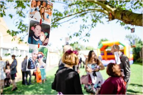 Photographs hanging from trees at wedding 