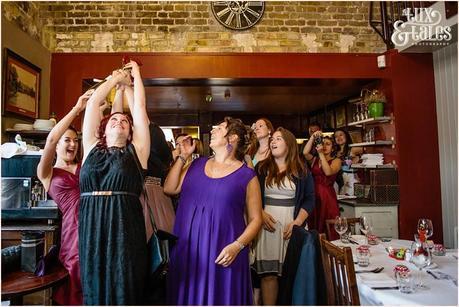 Women catch bouquet at London wedding Inn at Kew Gardens