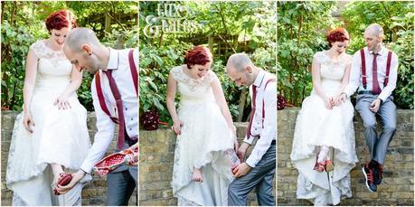 Groom helps bride put on red and black wedding shoes 