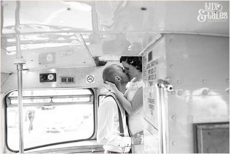 Bride and groom kiss on the stairs of lonson wedding bus