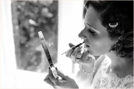 Bridal preparation wedding photography with bride applying lipstick in mirror