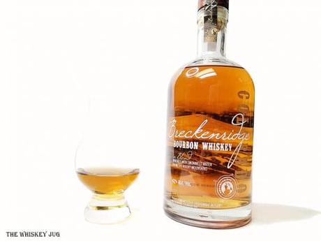 White background tasting shot with the Breckenridge Bourbon Whiskey, A Blend bottle and a glass of whiskey next to it.