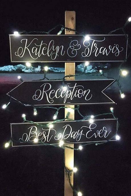 popular wedding signs direction on a black background in the evening in the lights megs truly via instagram