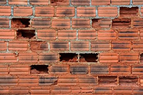 a broken brick wall with missing bricks