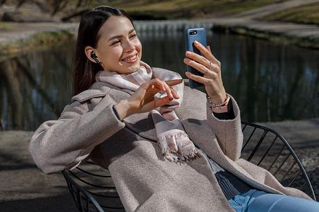 Woman using Redux Buds while watching through her phone