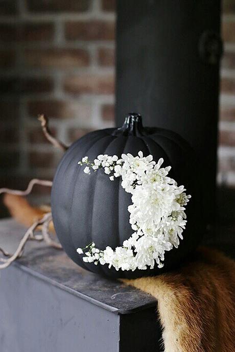 halloween wedding ideas black pumpkin on which lined with delicate white flowers in the form of a month themerrythought