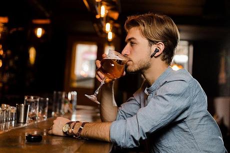 A man using xfyro headphones in a bar