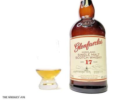 White background tasting shot with the Glenfarclas 17 Years bottle and a glass of whiskey next to it.