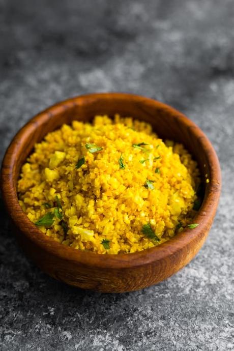 golden turmeric cauliflower rice in brown bowl