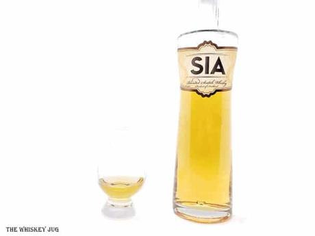 White background tasting shot with the SIA Blended Scotch bottle and a glass of whiskey next to it.