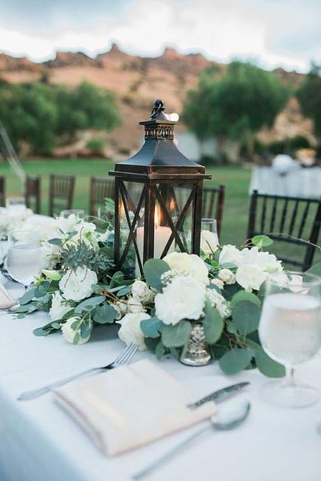rustic wedding lanterns with candles surrounded by white flowers anya kernes photography